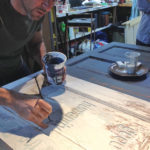 Artist Tim Webb stencils phrases onto vintage doors to create unusual headboards at Arowhon