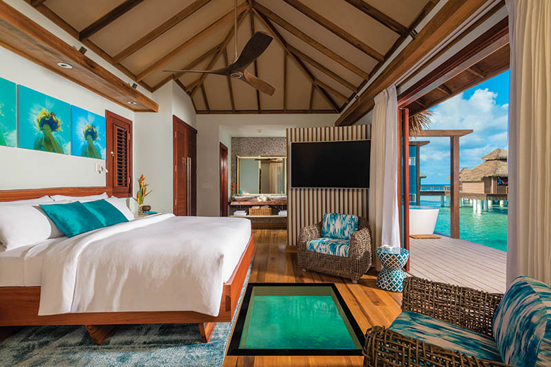 0402 ROMANCE - Sandals Resorts_Over-the-Water Bungalows_bedroom with glass floor